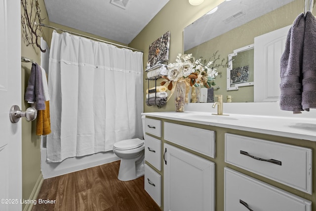 full bath featuring vanity, toilet, wood finished floors, and visible vents