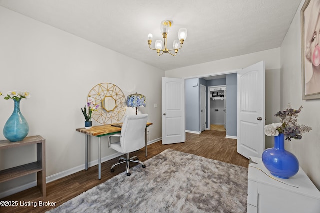 home office featuring a notable chandelier, baseboards, and wood finished floors