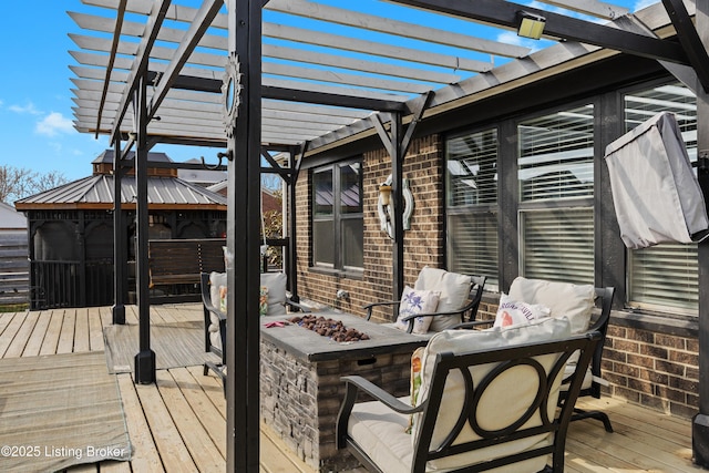 wooden terrace featuring an outdoor living space with a fire pit and a pergola