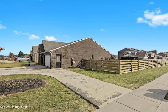 view of property exterior featuring brick siding, concrete driveway, an attached garage, and fence