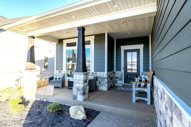 property entrance with covered porch and stone siding