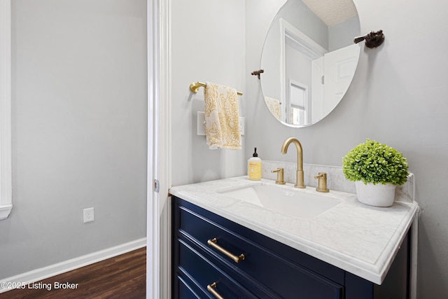 bathroom featuring vanity, wood finished floors, and baseboards