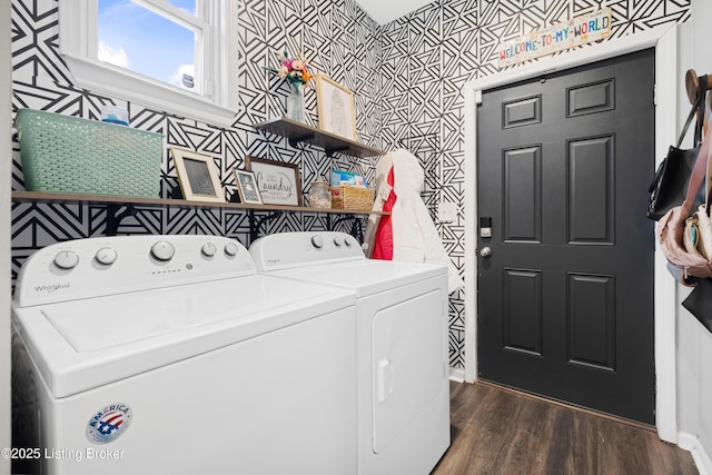 washroom featuring washing machine and clothes dryer, laundry area, wallpapered walls, and dark wood-style floors