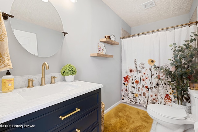 full bathroom featuring visible vents, a shower with curtain, toilet, a textured ceiling, and vanity