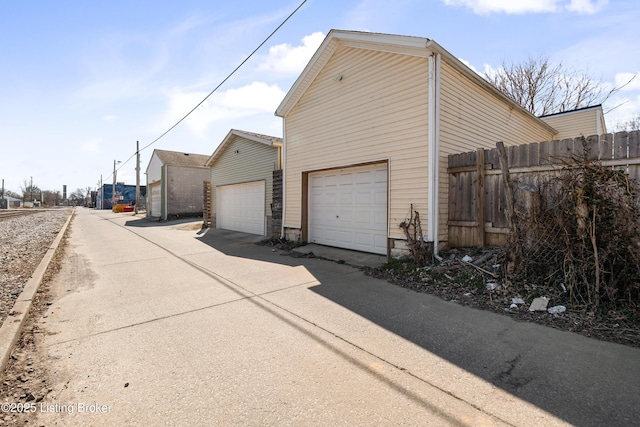 view of home's exterior with a garage and fence