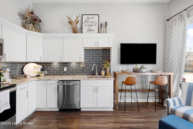 kitchen with a sink, tasteful backsplash, appliances with stainless steel finishes, and dark wood finished floors