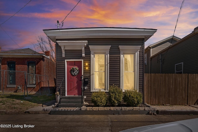 shotgun-style home with entry steps and fence