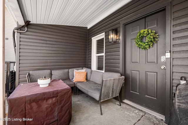 entrance to property with covered porch and outdoor lounge area