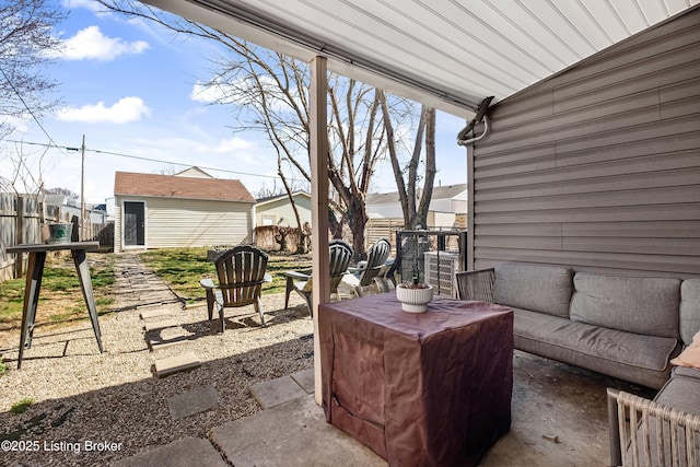 view of patio / terrace with an outbuilding, a shed, and fence