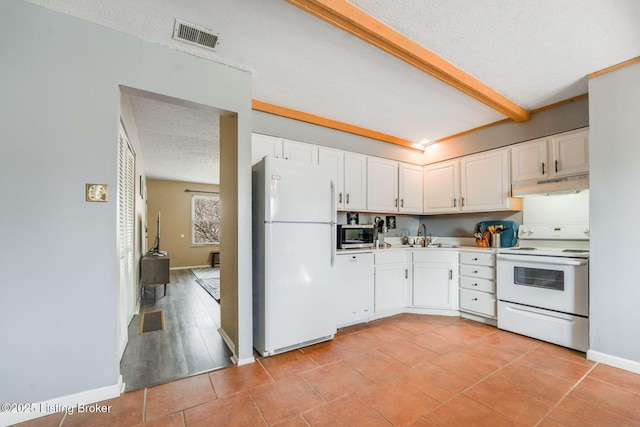 kitchen with visible vents, under cabinet range hood, a textured ceiling, white cabinetry, and white appliances