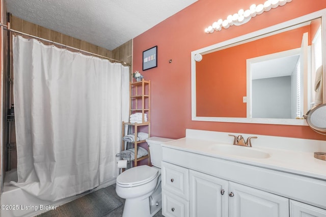 bathroom featuring toilet, a textured ceiling, vanity, and shower / tub combo