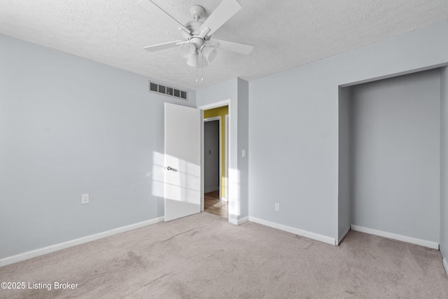 unfurnished bedroom featuring a ceiling fan, baseboards, visible vents, a textured ceiling, and carpet flooring