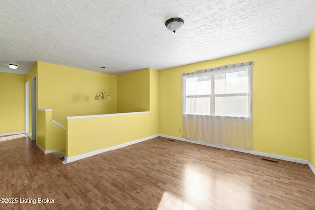 empty room with baseboards and wood finished floors