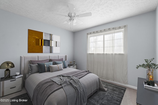 carpeted bedroom featuring ceiling fan, baseboards, and a textured ceiling