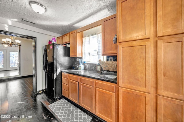 kitchen with visible vents, tasteful backsplash, black refrigerator with ice dispenser, tile counters, and dark wood-style flooring