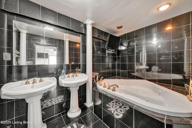 bathroom featuring tile patterned floors, tile walls, and a whirlpool tub