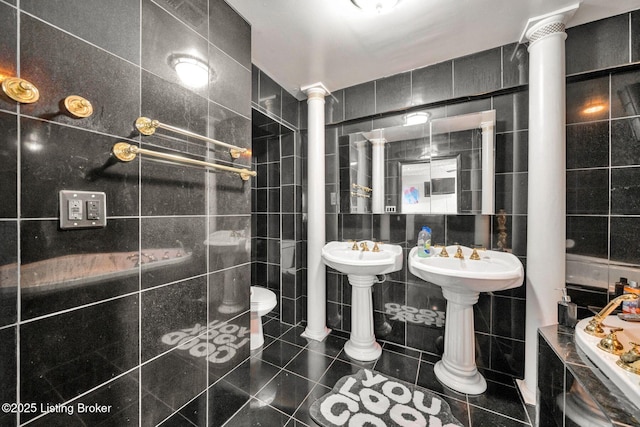 full bath with tile walls, toilet, tile patterned floors, and decorative columns