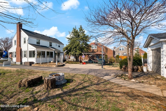 rear view of property featuring a yard and a chimney