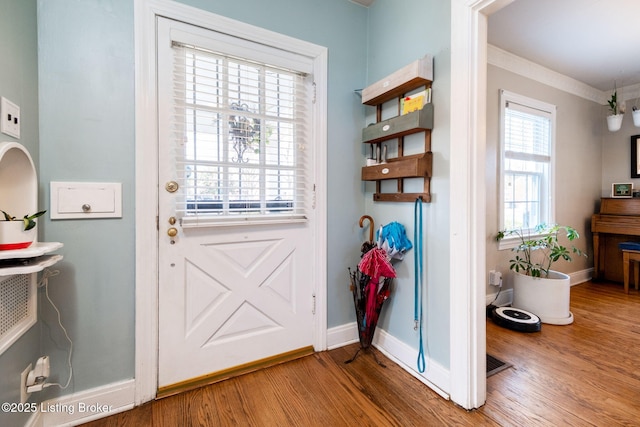 doorway with wood finished floors and baseboards