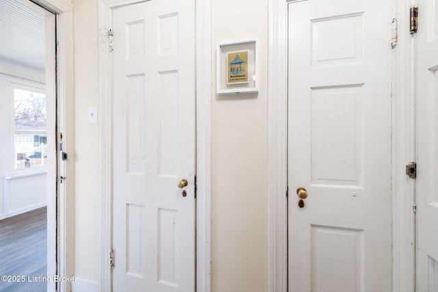 corridor featuring baseboards and wood finished floors