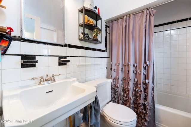 bathroom with a sink, toilet, tile walls, and shower / bath combination with curtain