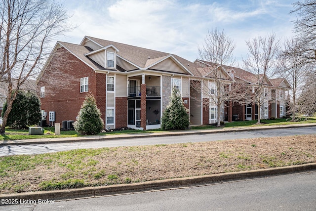 view of front of property featuring brick siding and central AC