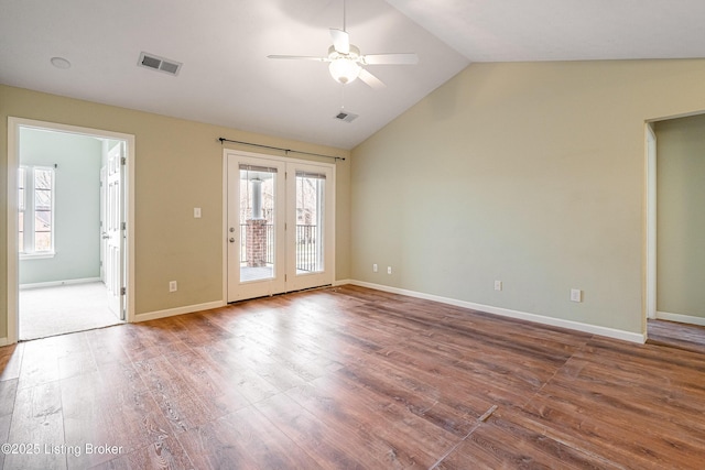 unfurnished room with vaulted ceiling, visible vents, a ceiling fan, and wood finished floors