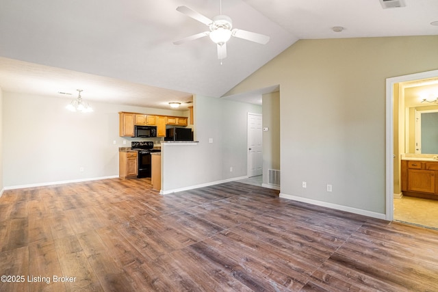 unfurnished living room featuring baseboards, lofted ceiling, dark wood finished floors, and ceiling fan with notable chandelier