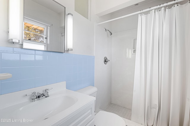 full bath with curtained shower, vanity, toilet, and tile walls