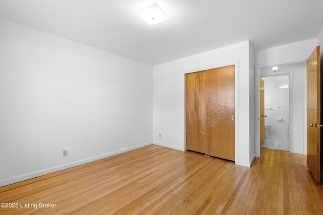 unfurnished bedroom featuring a closet, light wood-style flooring, and baseboards