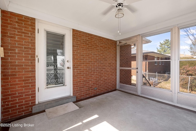 unfurnished sunroom with ceiling fan