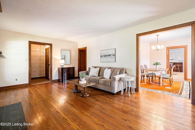 living area featuring wood finished floors, baseboards, and a chandelier