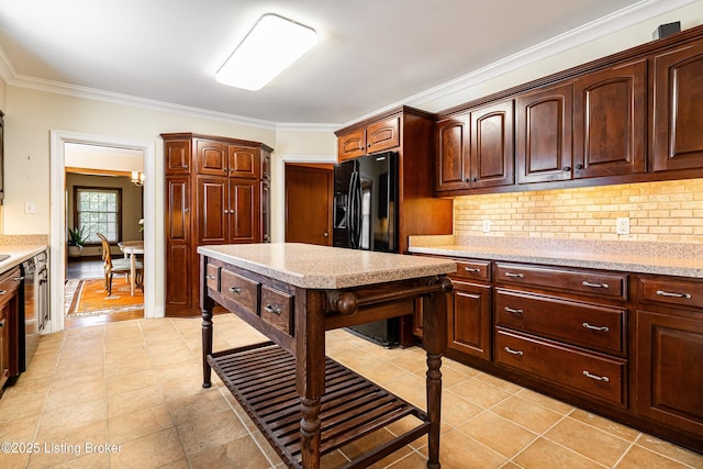 kitchen with decorative backsplash, black fridge, light countertops, and ornamental molding