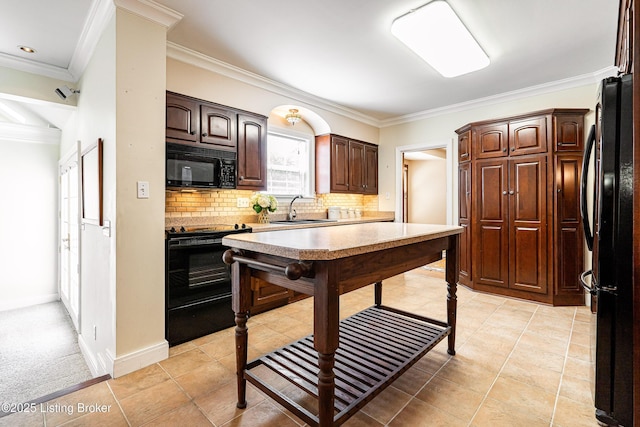 kitchen featuring black appliances, ornamental molding, a sink, decorative backsplash, and dark brown cabinets