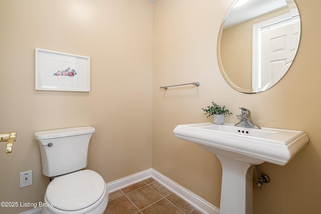 bathroom featuring tile patterned floors, baseboards, and toilet