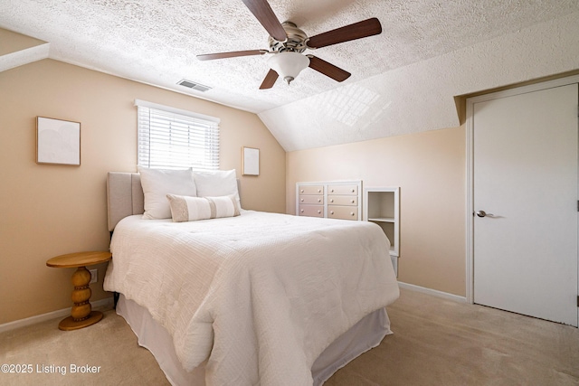 bedroom with visible vents, light carpet, a textured ceiling, and vaulted ceiling