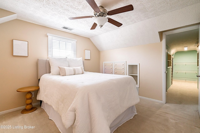 bedroom with light carpet, visible vents, a textured ceiling, and lofted ceiling