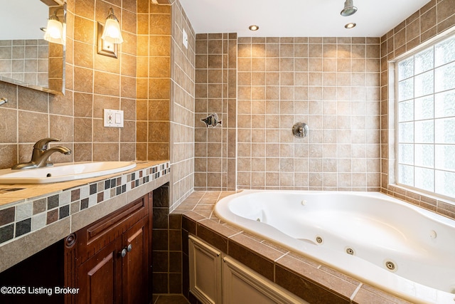 bathroom with vanity, tile walls, and a whirlpool tub