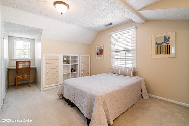 bedroom featuring a textured ceiling, visible vents, and light carpet