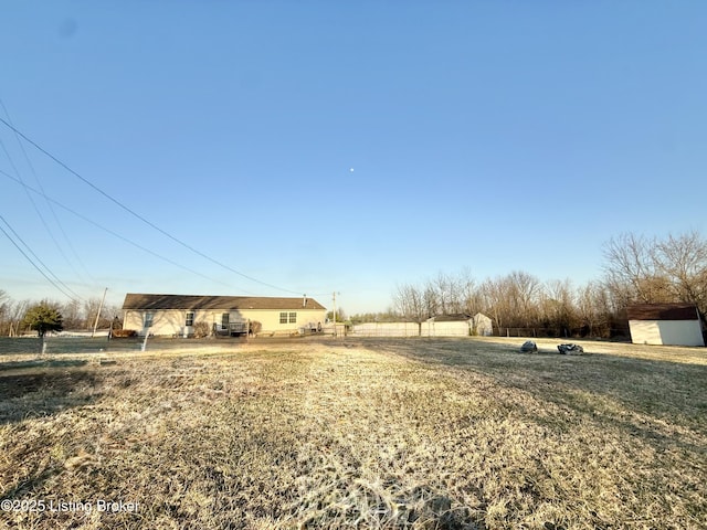 view of yard featuring a rural view, a storage shed, and an outdoor structure