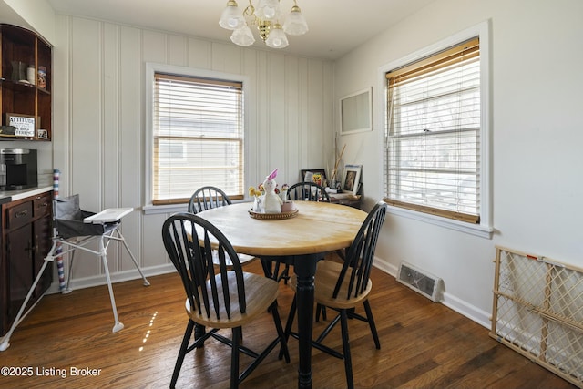 dining room with an inviting chandelier, baseboards, visible vents, and dark wood-style flooring