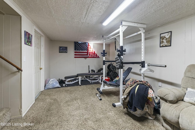 exercise area with carpet flooring and a textured ceiling