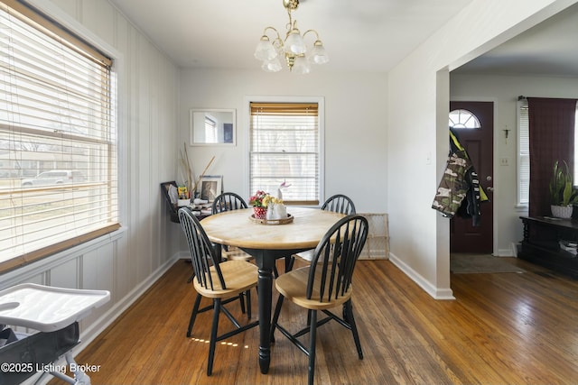 dining area featuring baseboards, plenty of natural light, an inviting chandelier, and wood finished floors