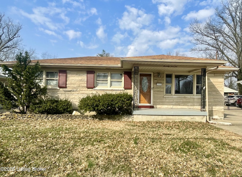 ranch-style home with covered porch and a front lawn