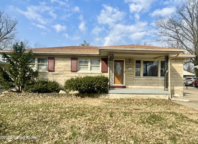 ranch-style home with covered porch and a front lawn