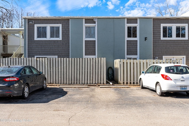 view of front of home featuring fence and uncovered parking