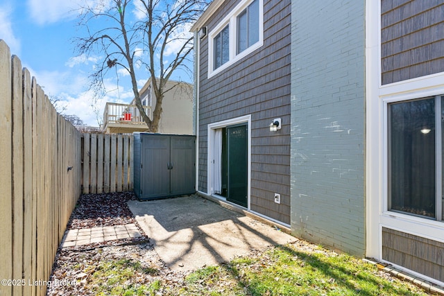 view of patio featuring a storage shed, an outbuilding, and a fenced backyard