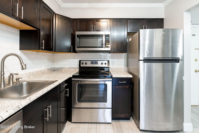 kitchen featuring a sink, tasteful backsplash, stainless steel appliances, crown molding, and dark brown cabinets