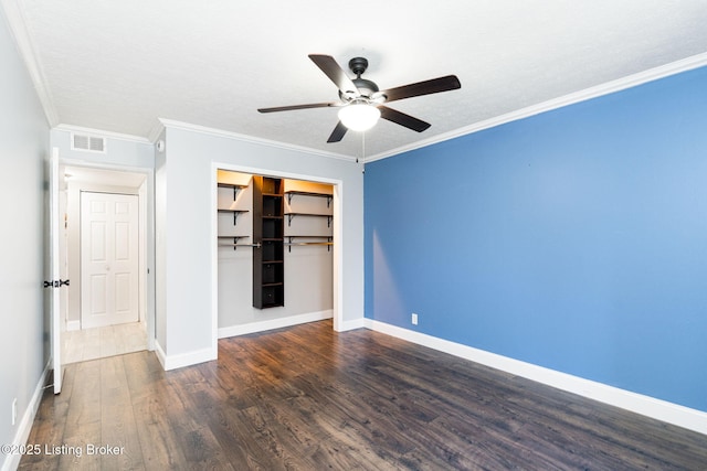 unfurnished bedroom featuring visible vents, baseboards, a closet, and wood finished floors