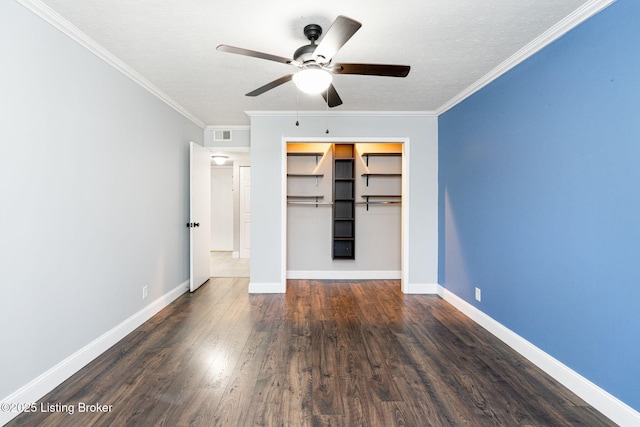 unfurnished bedroom featuring crown molding, wood finished floors, baseboards, and a closet